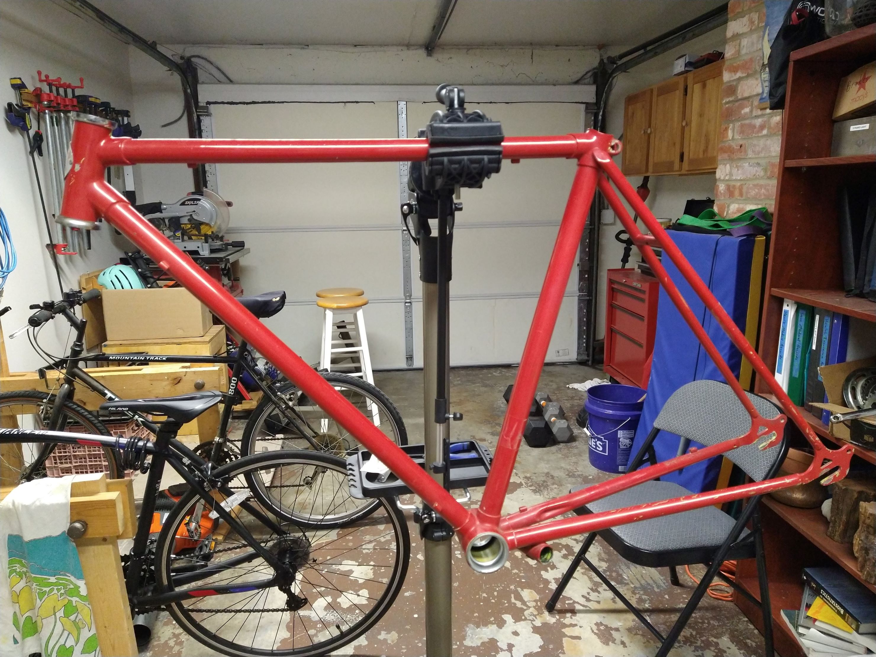 image of a bare bike frame in a stand in a messy garage